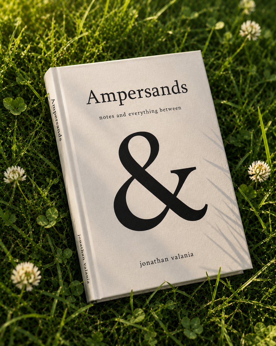 Ampersands hardcover by Jonathan Valania resting in grass and clover